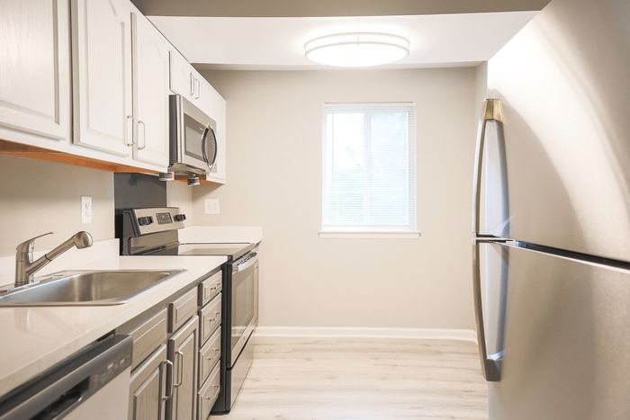 Modern kitchen at ReNew White Marsh with sleek stainless steel appliances, elegant white cabinetry, and abundant natural light.