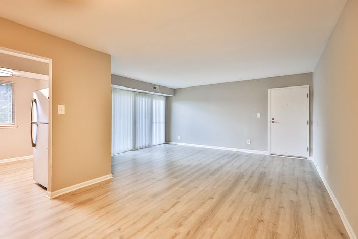 Contemporary open-plan living space at ReNew White Marsh featuring sleek laminate floors and abundant natural light, perfect for modern living.