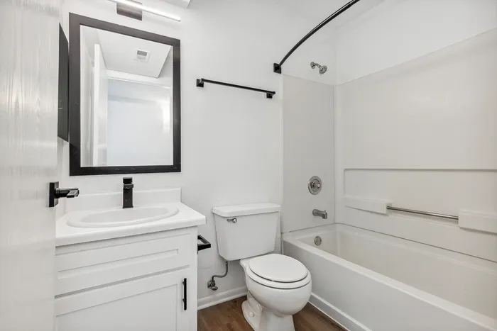 Sleek modern bathroom with elegant fixtures, a large mirror, and a pristine bathtub, perfect for relaxation.