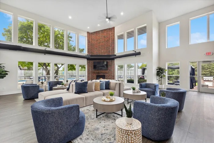 Bright and spacious lounge area with elegant seating arrangements, modern decor, and large windows showcasing a scenic outdoor view.