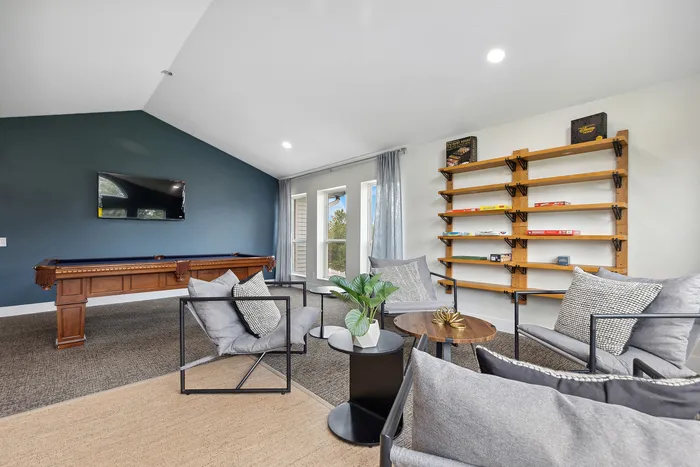 Modern lounge area with plush seating, a stylish pool table, and wall-mounted TV, perfect for relaxation and entertainment.