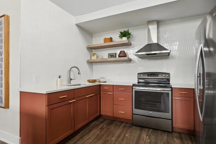 Chic modern kitchen with sleek stainless steel appliances, warm copper-toned cabinets, and elegant open shelving.