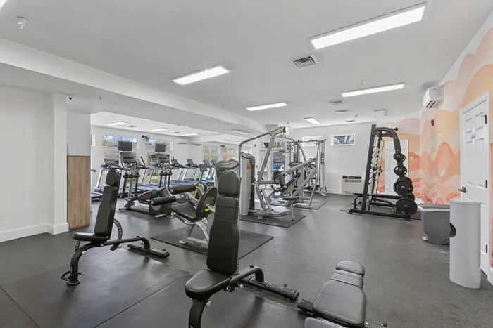 Bright, spacious fitness center at ReNew Howard Crossing with modern gym equipment and vibrant decor offering a dynamic workout atmosphere.