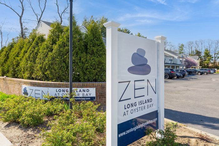 Inviting entrance sign for Zen Long Island at Oyster Bay, surrounded by lush greenery and serene atmosphere.