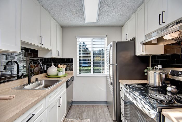 Contemporary kitchen space with sleek appliances, elegant cabinetry, and abundant natural light at ReNew Dash Point.