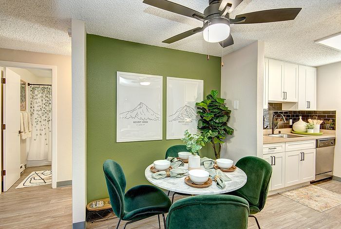 Open-concept dining area with green accent wall and art at ReNew Dash Point.