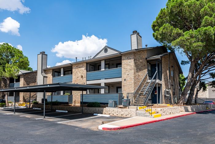 Charming residential apartment building with modern amenities and lush greenery, featuring spacious balconies and covered parking.