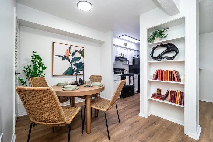 Charming dining area with wicker chairs and elegant kitchen, featuring modern decor and chic shelving.