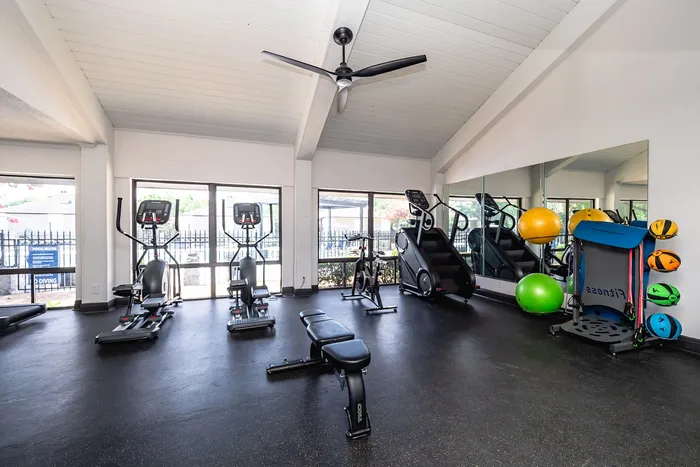 Bright and modern fitness center featuring state-of-the-art equipment and large windows for natural light.