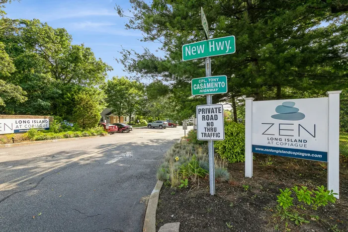 Entrance to Zen Long Island at Copiague, featuring lush greenery and clear signage on a sunny day.