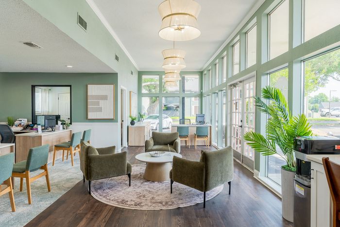 Bright and inviting office space with modern furniture, large windows, and elegant decor.