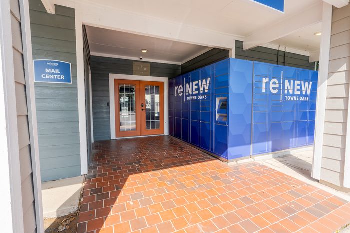 Modern mail center at reNEW Towne Oaks featuring secure package lockers and welcoming entrance.