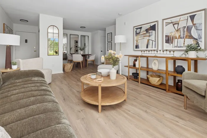 Chic living room with modern decor, featuring a cozy sofa, elegant wall art, and a stylish wooden coffee table, perfect for relaxation and entertaining.