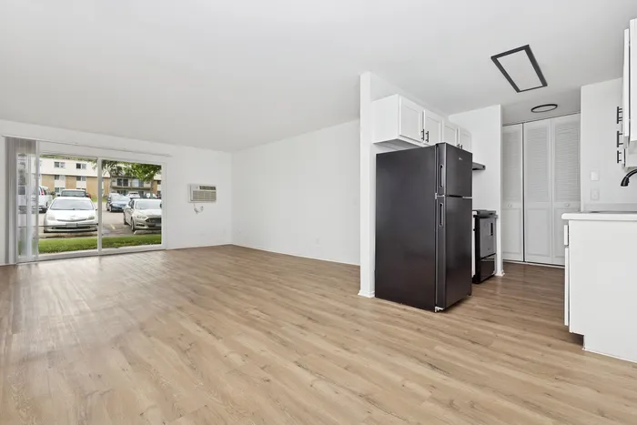 Bright open-concept living space with sleek hardwood floors and modern kitchen appliances.