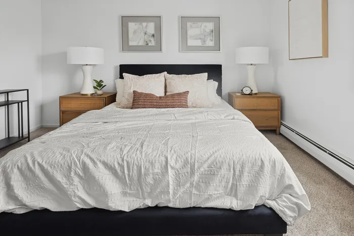 Elegant bedroom featuring a cozy double bed with plush pillows, chic side tables, and modern decor in a serene ambiance.