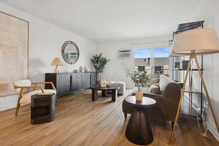 Bright and modern living room with elegant decor, featuring a cozy sofa, chic wooden furniture, and large window for natural light.