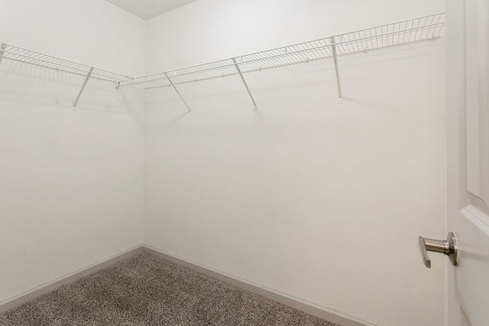 Spacious walk-in closet with ample shelving, ready for personalized storage solutions.