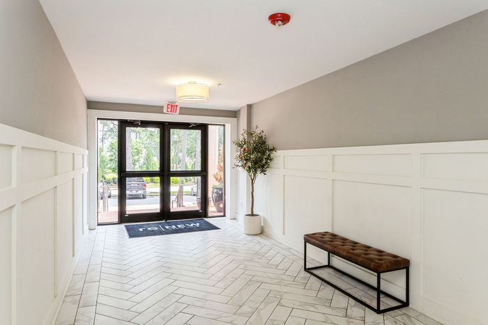 Inviting apartment entryway featuring modern tile flooring, contemporary lighting, and elegant decor.