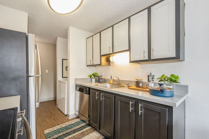 Modern kitchen with sleek countertops, stainless steel appliances, and stylish two-tone cabinets, perfect for culinary adventures.