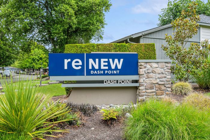 Inviting entrance sign for ReNew Dash Point surrounded by lush greenery and natural stone elements.