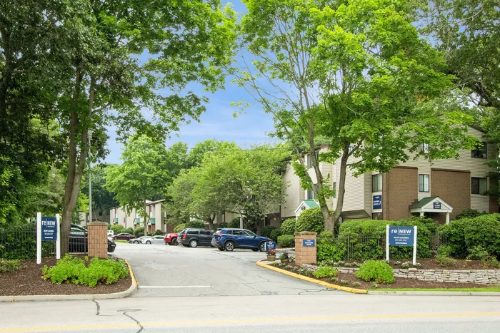 Charming apartment complex surrounded by lush greenery and vibrant landscaping, offering a peaceful and inviting atmosphere.