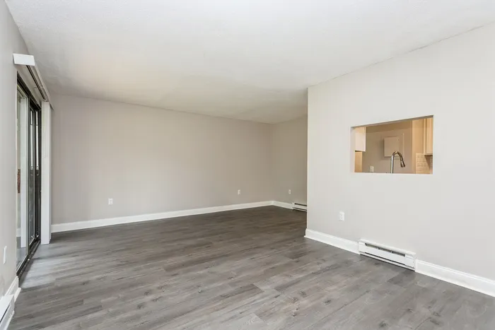 Bright and spacious open-plan living area with sleek hardwood flooring and modern finishes, offering a perfect canvas for customization.