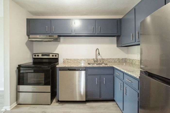 Modern kitchen with sleek granite countertops, stainless steel appliances, and chic gray cabinets.