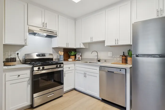 Modern kitchen with sleek stainless steel appliances and elegant white cabinetry, offering a bright and functional space for cooking and entertaining.