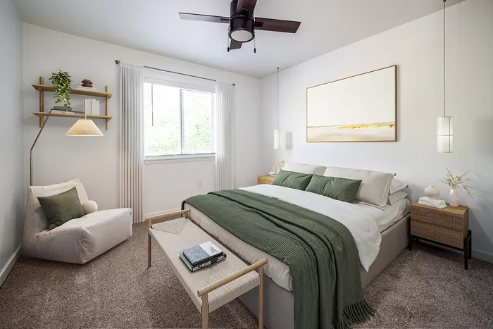 Elegant bedroom with modern decor, featuring a cozy bed with green accents, stylish artwork, and warm natural lighting.
