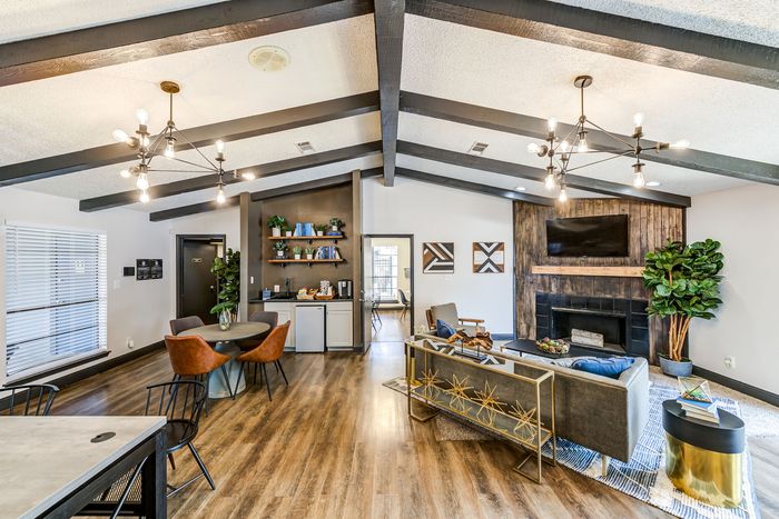 Chic open-concept living space with high ceilings, modern lighting fixtures, stylish wood flooring, and elegant furnishings.