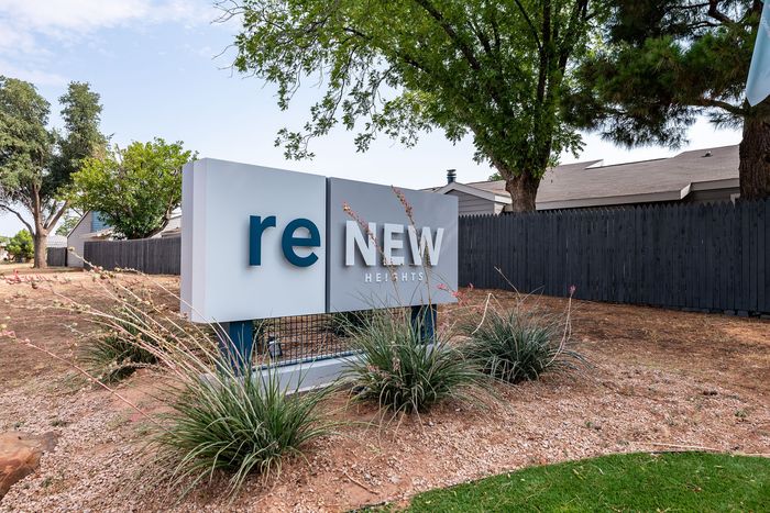 Inviting entrance sign for ReNew Heights, surrounded by lush greenery and modern design.