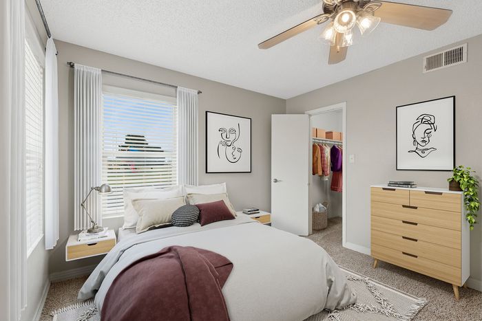 Bright and cozy bedroom with a modern ceiling fan, stylish decor, and ample closet space for a serene living experience.