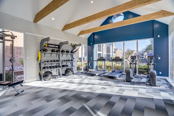 Modern fitness center with state-of-the-art equipment, large windows, and natural light for an energizing workout experience.