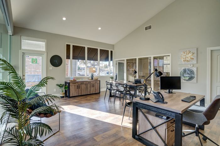 Bright, airy office space with modern wooden flooring, large windows, and sleek furnishings. Perfect for a professional, contemporary work environment.