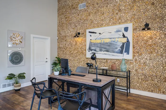 Chic office space with trendy wooden accent wall, modern art, and lush greenery, creating an inviting and stylish atmosphere.