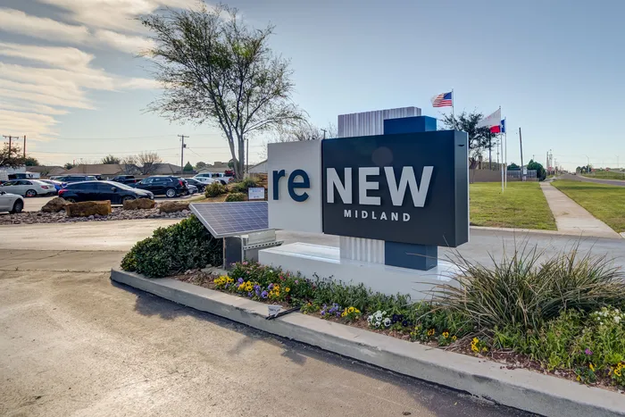 Inviting entrance sign of ReNew Midland, surrounded by vibrant flowers and well-maintained landscaping, promising a welcoming community atmosphere.