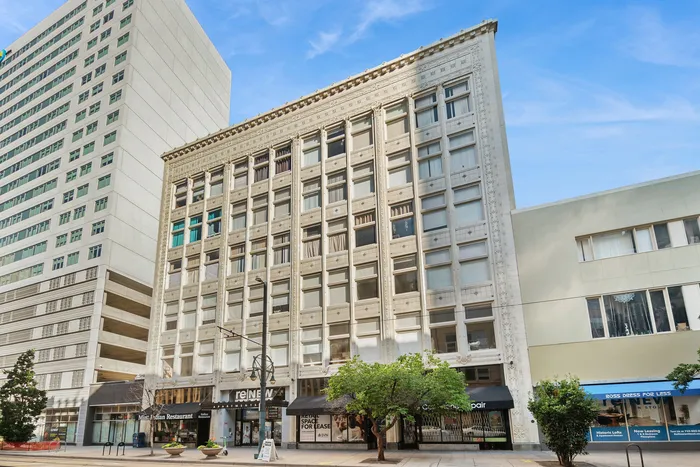Charming historic building with elegant architectural details, offering urban living spaces, centrally located on a bustling city street.