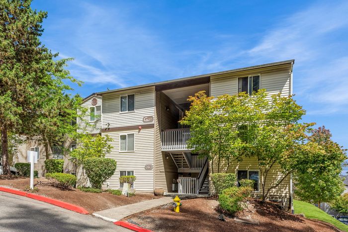 Charming apartment building surrounded by lush greenery, featuring modern architecture and a peaceful outdoor setting.