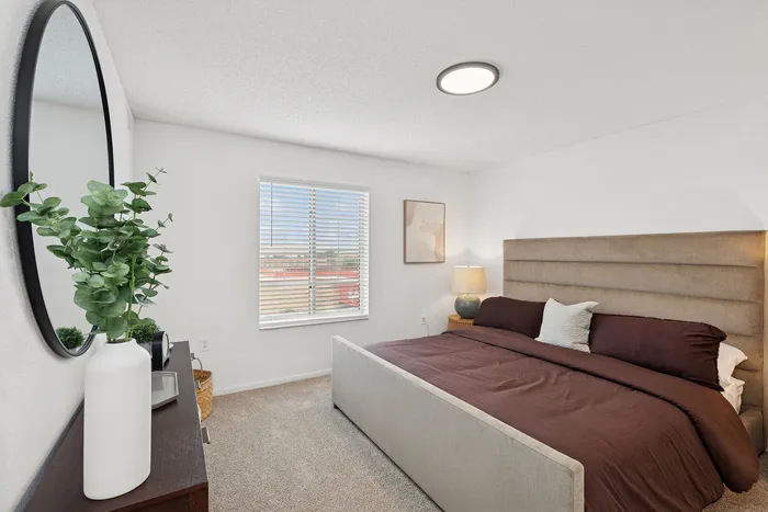 Inviting bedroom with plush bedding, natural light, and modern decor for ultimate relaxation.