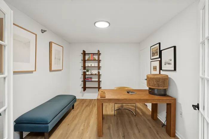Chic home office with a sleek wooden desk, modern bookshelf, and stylish wall art, set on elegant wooden flooring.