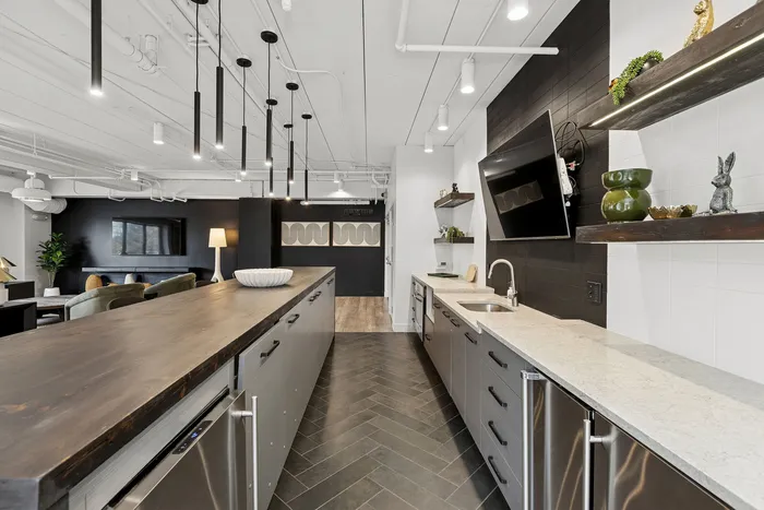 Sophisticated open-plan kitchen and living area with sleek countertops, modern pendant lighting, and stylish decor.