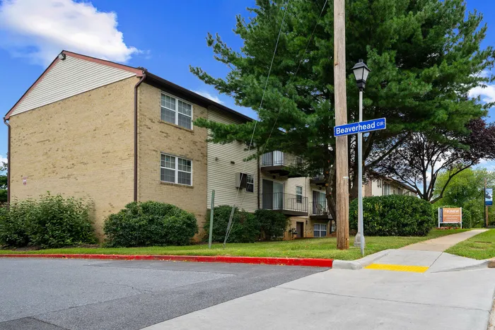 Charming apartment building on Beaverhead Cir, nestled among lush greenery and mature trees, offering a peaceful living environment.