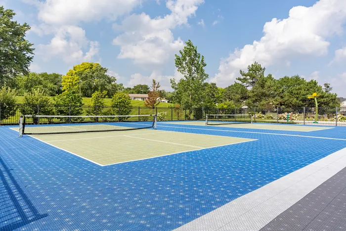 Vibrant outdoor tennis courts surrounded by lush greenery and scenic views, perfect for recreational activities.