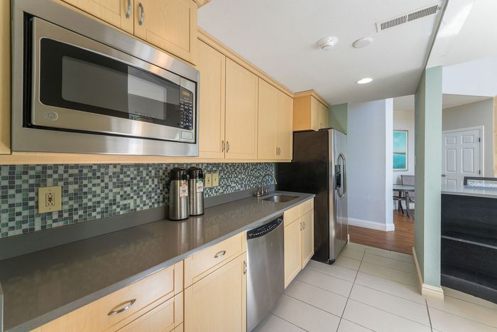 Modern kitchen with sleek stainless steel appliances, elegant tile backsplash, and spacious wooden cabinetry for a stylish culinary experience.