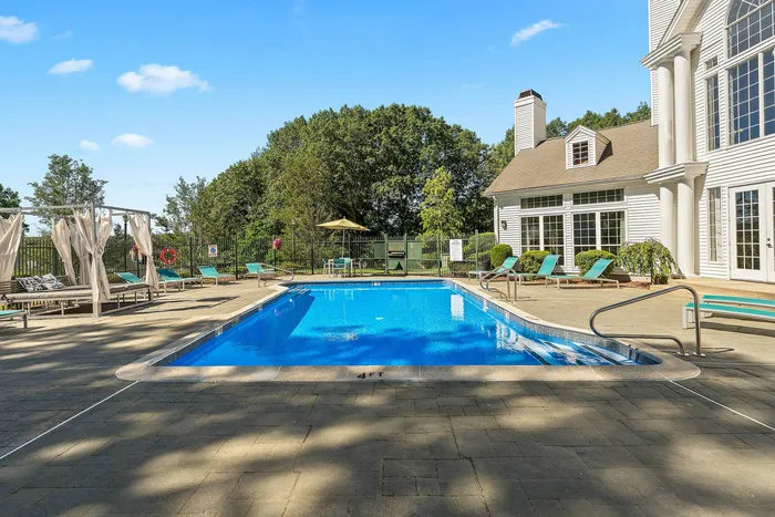 Luxurious outdoor swimming pool with elegant sun loungers, stylish cabanas, and lush greenery, perfect for relaxation and leisure.