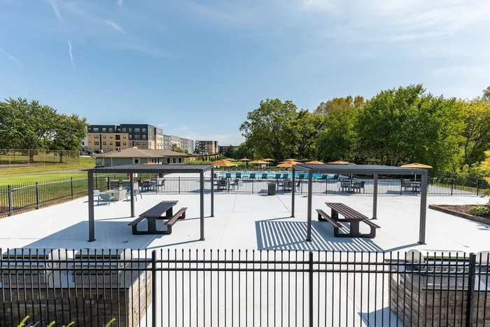 Chic outdoor recreational area featuring shaded seating, picnic tables, and vibrant landscaping, perfect for relaxation and social gatherings.