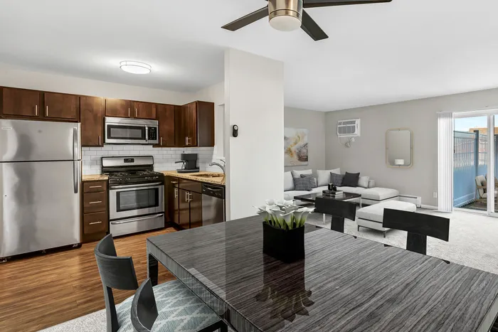 Modern open-concept living space with sleek kitchen, stainless steel appliances, stylish dining area, and cozy lounge offering abundant natural light.