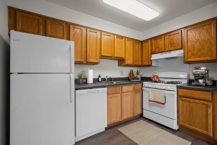 Charming kitchen with rich wooden cabinets, modern appliances, and sleek countertops creating a warm and inviting atmosphere.