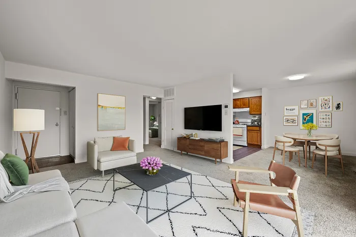 Chic living room with modern furniture, abstract art, and open layout connected to a cozy dining area and kitchen.