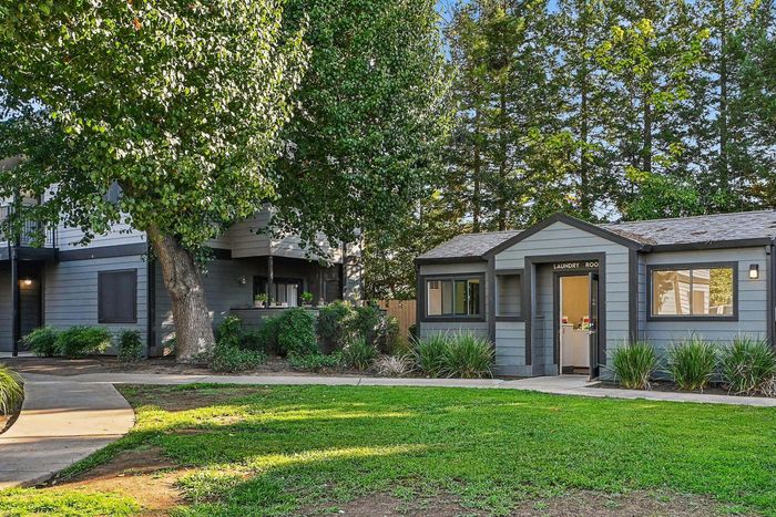 Charming residential community with lush greenery and modern architecture, featuring a convenient on-site laundry room.